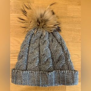Fraas grey cable knit toque with beige and black faux fur Pom Pom. Like-new.